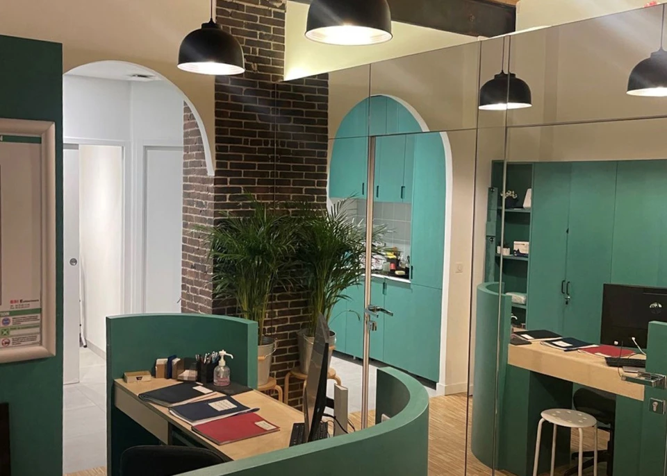 Deux professionnels en tenues de travail grises examinent des échantillons de pierre naturelle dans un atelier ou showroom