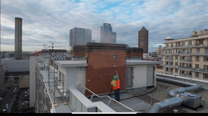 Vieille commode rénovée aux motifs sculptés turquoise située derrière un lit double dans une maison de campagne en bois, derrière un mur
